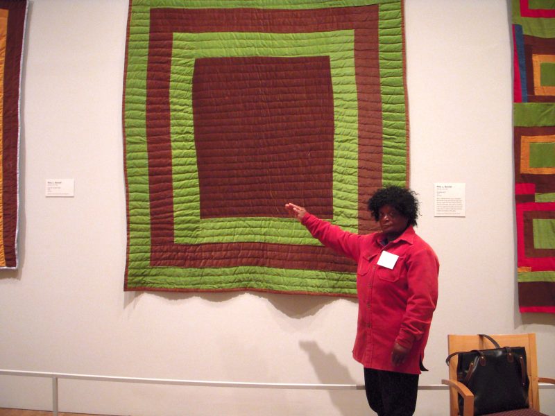 Sarah Benning in front of one of her courderoy quilts.