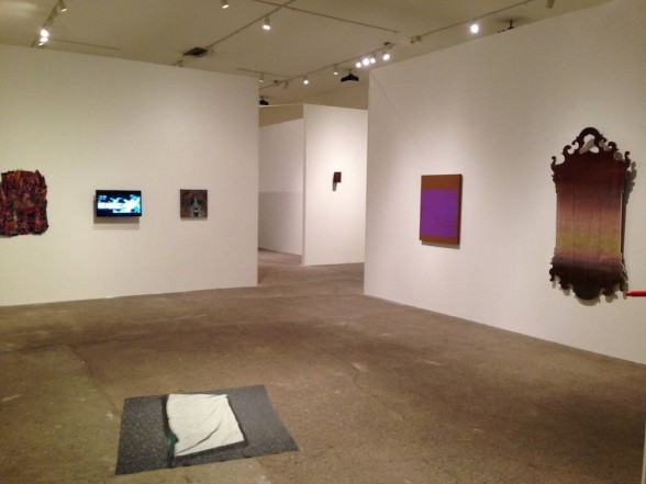 gallery with paintings, video on the wall and painting on the floor