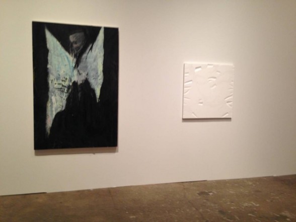 a black and with painting and a white sculpture on a wall