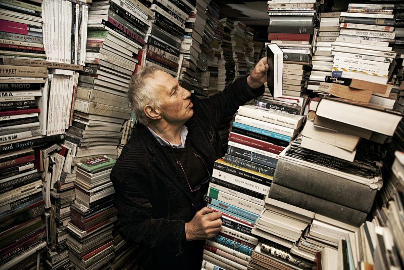 Léo, searching through the stacks in his Paris bookstore, Alias. Photo: © Victor Matussière : http://victormatussiere.com