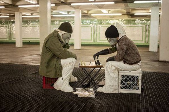 Wearing hazmat suits in a concourse below Center City, artists Jerry Kaba (left) and Meghan O'Donnell, inspired by a concourse myth, play chess as part of a guerrilla-arts fest. CHRIS FASCENELLI.