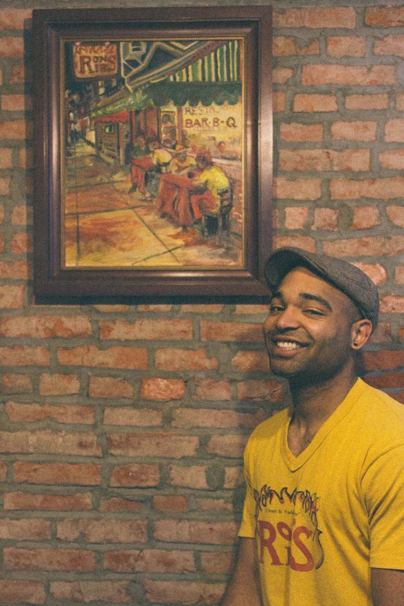 Brandon Washington poses with photo of Ron's Ribs, closed now, which was established and run by his father, Ron Washington
