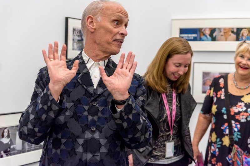 John Waters discussing one of his artworks, with curator Kristen Hileman at the Baltimore Museum of Art, Media Preview, Indecent Exposure. Photo by Chuck Patch, with permission