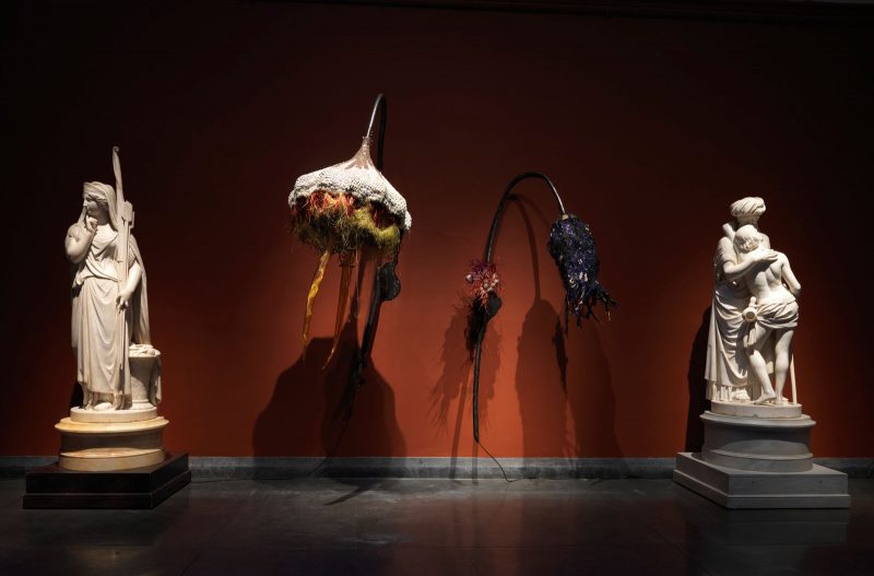 Installation view (left to right): Rina Banerjee (b. 1963) "Excessive flower...," 2017, Thread cotton, cowrie shells, glass bottles, wire, linen, silk, mirrors, vintage trim, cable, steel armature, copper tubes, seed beads, porcupine needles, cock feathers, peacock hairs, faux eyelashes, speaker, Frozen Charlotte doll heads, 48 x 36 x 72 in. Pennsylvania Academy of the Fine Arts, Philadelphia, Museum Purchase, 2016.37a; "Women did do this...," 2017, Thread cotton, cowrie shells, glass bottles, wire, linen, silk, mirrors, vintage trim, cable, steel armature, copper tubes, seed beads, porcupine needles, cock feathers, peacock hairs, faux eyelashes, speakers, Frozen Charlotte doll heads, 48 x 76 x 32 in. Pennsylvania Academy of the Fine Arts, Philadelphia, Museum Purchase, 2016.37b, Image courtesy: Pennsylvania Academy of the Fine Arts/ Barbara Katus, Rina Banerjee: Make Me a Summary of the World, October 27, 2018–March 31, 2019