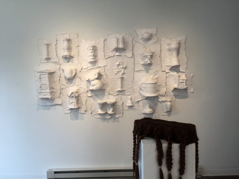 Top: Jacqueline Tull, Death Masks, 2017, Plaster gauze, 5 ft x 5 ft x 12 in. Bottom right: Natasha Le Sourd, Hairy Block, 2019, Foam, extension hair, 30 x 5 in. From "Additional Assembly Required" at Automat.