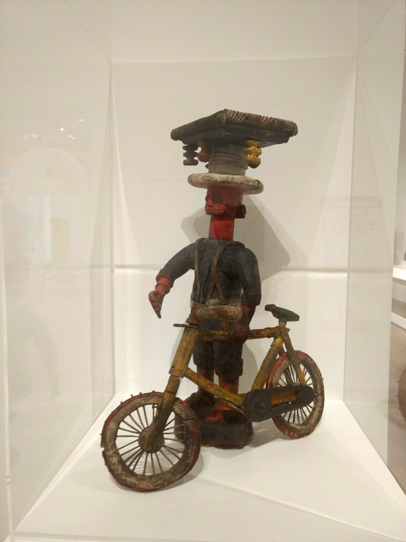 Man with Bicycle, Unknown Yoruba Artist. Mid 20th century. Polychromed wood. From Art of Global Africa at the Newark Museum. Courtesy Janyce Denise Glasper.