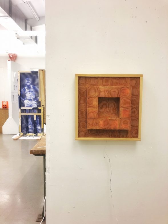 Brown, square wall sculpture containing a jutting out square. Courtesy Nina Valdera.