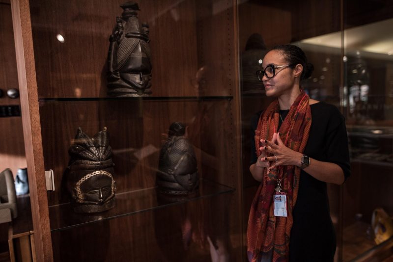 Monique Scott, Director of Museum Studies at Bryn Mawr College, standing in front of a glass case of sculptural art.