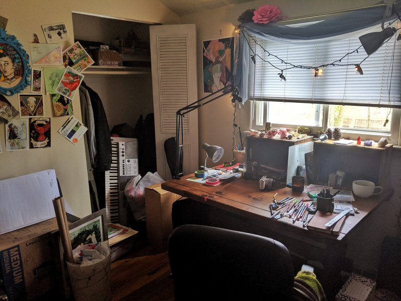 Sara Smith's home studio with a desk, pencils, and drawings hanging on the walls 