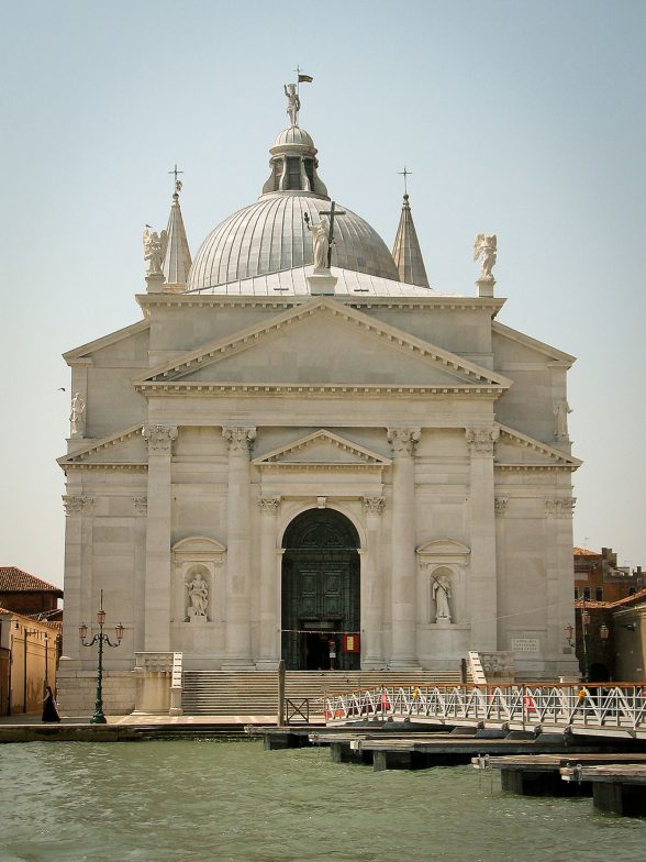 Large white and gray church on the lagoon in Venice.