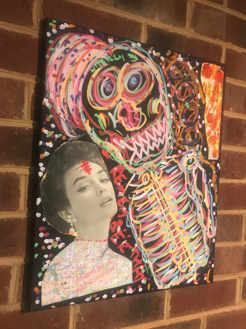Painting of a skull collaged with a photo of a woman on a black canvas.