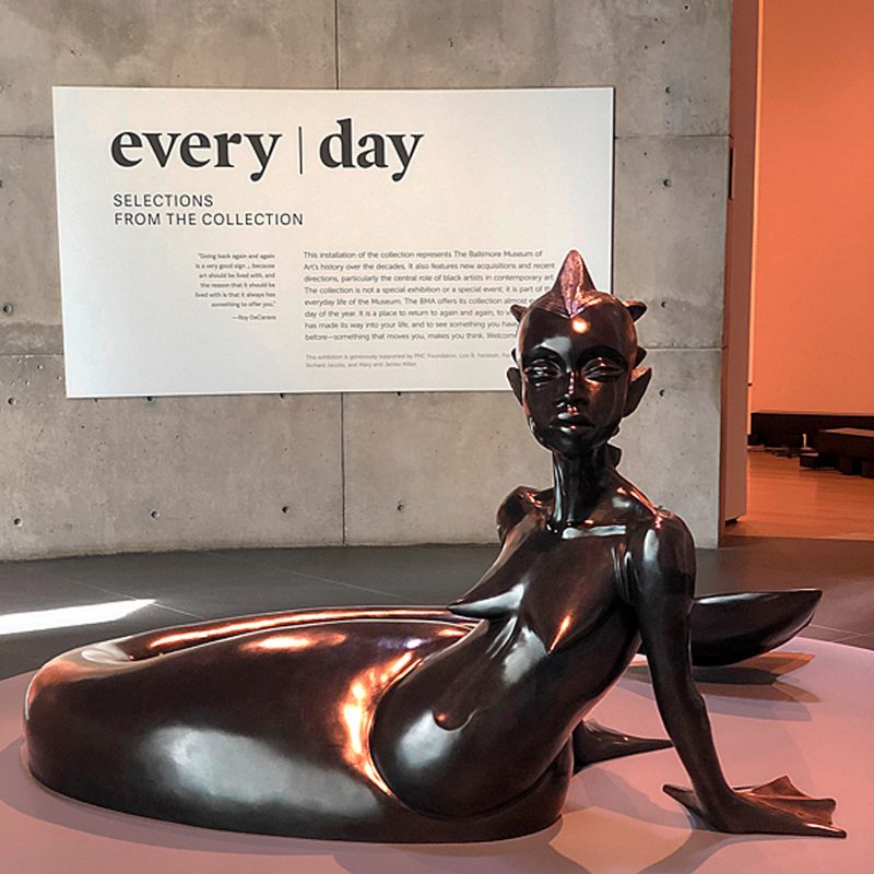 Statue of a seated woman with a mermaid tail at the Baltimore Art Museum.