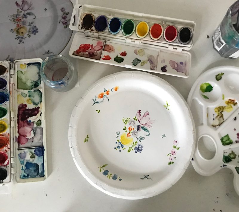 Paper plate painted with floral designs, an in progress work.