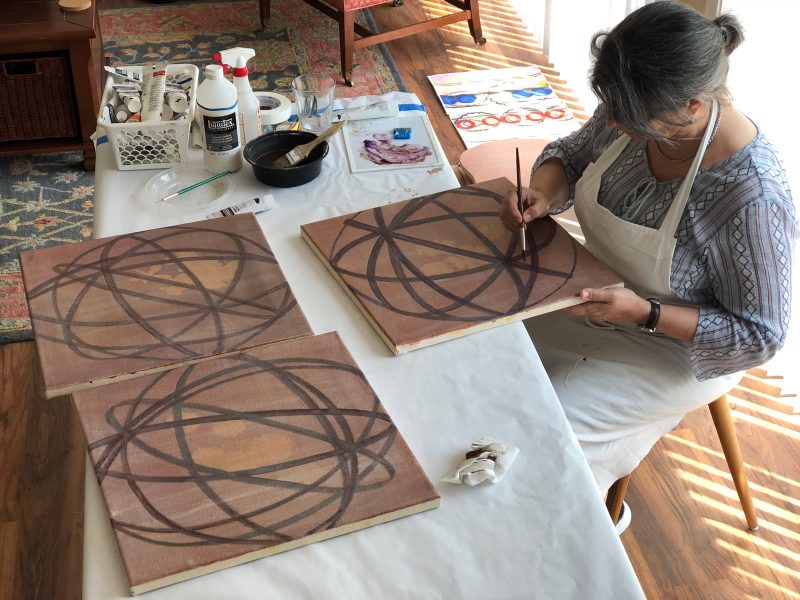 Artist in studio working on abstract painting