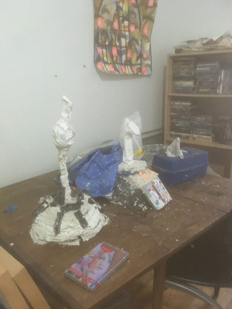 Studio table with plaster sculpture structures on them. 