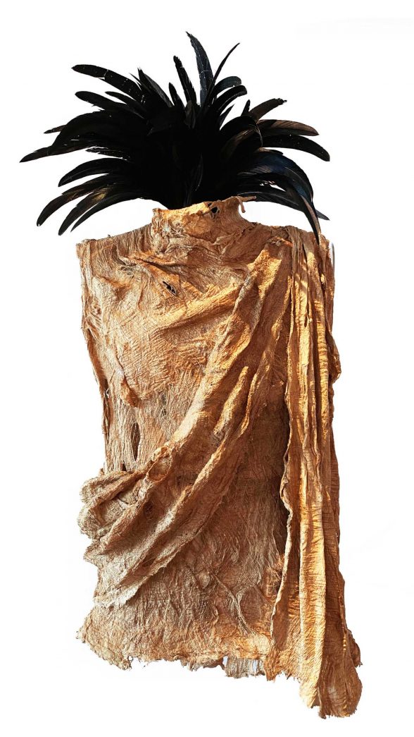 Sculpture of a gold clothing garment draped into the shape of a female torso with black feathers coming out of the neck.