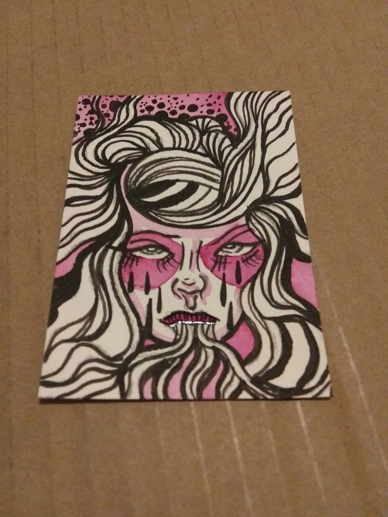 Marker drawing of a face with pink circles over their eyes shewing on their hair