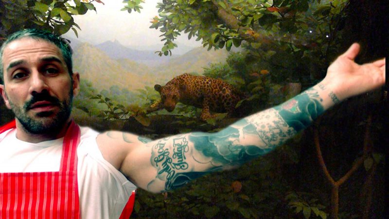 Photo collage of a man in a red apron showing off a tattoo superimposed onto an image of a tiger lurking in the trees in front of a clearing.
