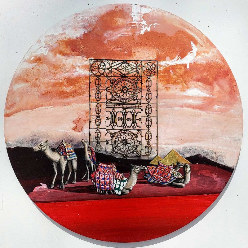 Circular canvas with camels and an ornate iron structure in front of a red setting sky.