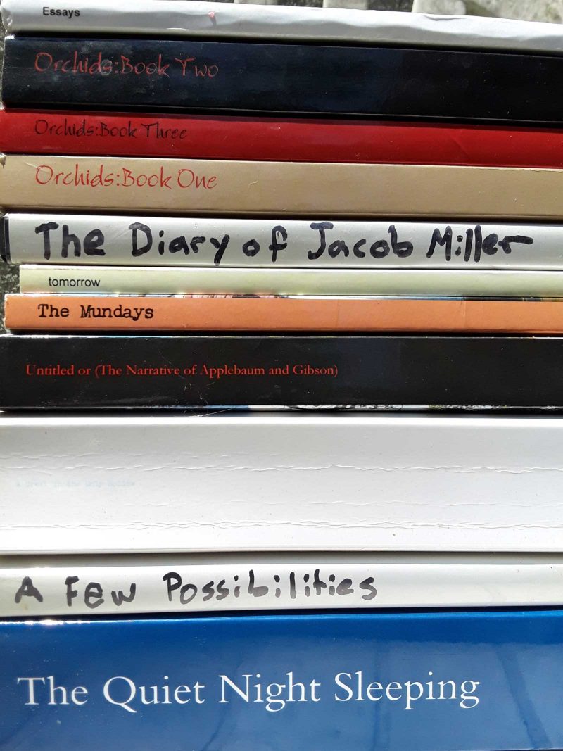 Stack of books, including "The Quiet Night Sleeping," "Orchids" (1-3), "The Diary of Jacob Miller," "A Few Possibilities," and more.