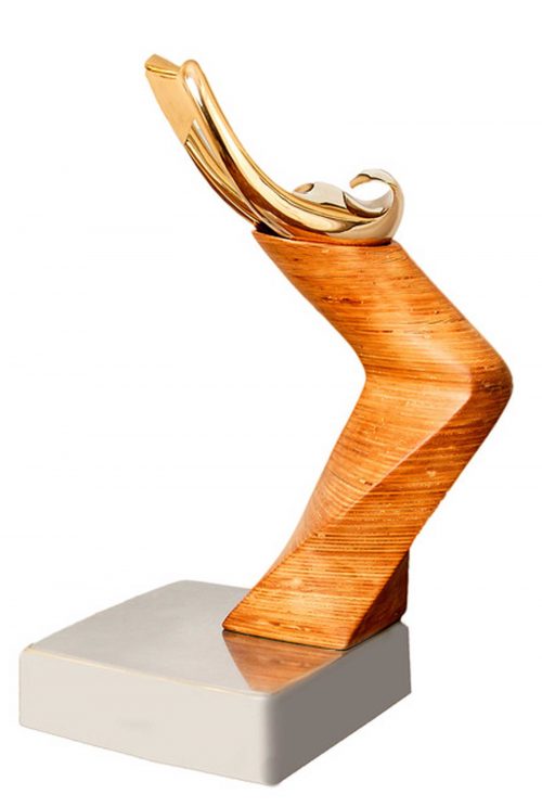 Wooden sculpture in a "c" shape with a golden swoosh-like shape mounted on the top