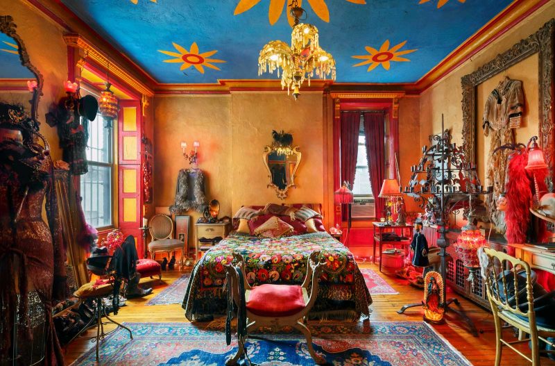 Bright and colorful bedroom with antiques littered throughout the room.