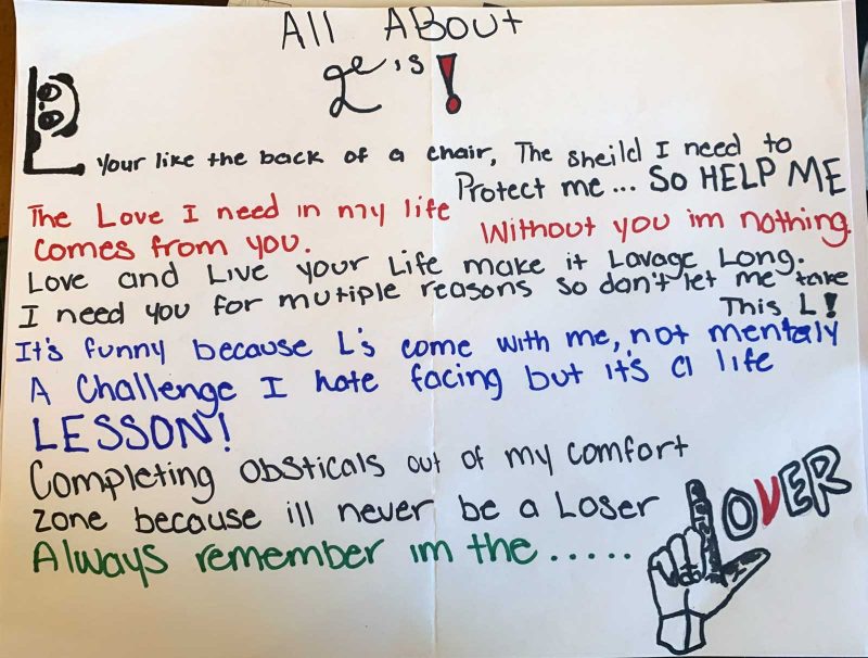 Alaza's poem written in many colors of markers with a drawing of two fingers in the shape of an "L" followed by "over" at the bottom.