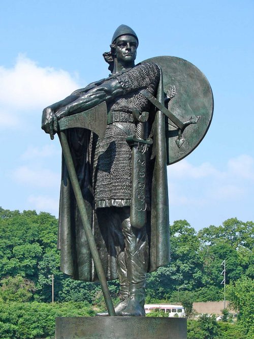 Statue of Thorfinn Karlsefni holding a sword out away from him and wearing a shield on his back.