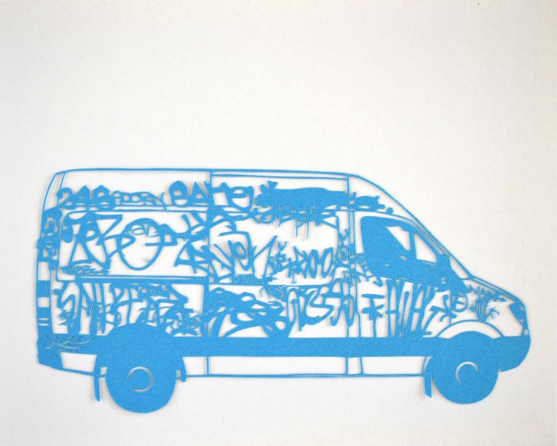 Cut paper artwork of a van covered in graffiti