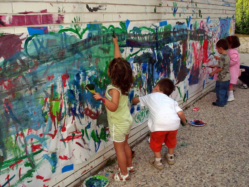 Children playing and painting on the walls