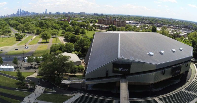 Aerial view of The Mann Center's large stage and seats, with trees and the Philadelphia skyline in the background.