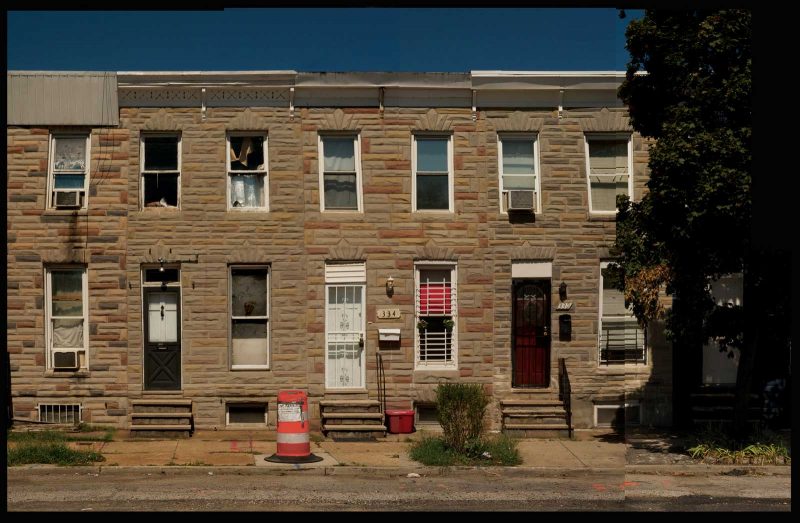 4 rowhouses on a Baltimore block, all of which have a Formstone facade.