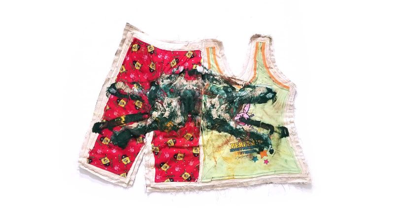 Children's clothes stitched together side-by-side-- on the left, red Spongebob Squarepants pirate pajama pants; on the right, a green tank top with Happy Bunny-- with a gestural, messy, image of a running rabbit painted on top.