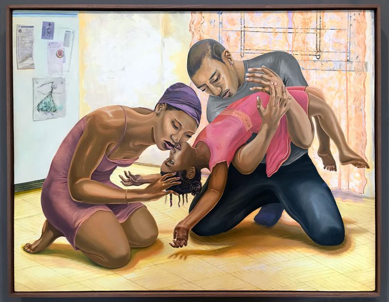Colorful painting in a dark frame shows a Black family in a dance-like pose with mother and father cradling and celebrating their young daughter.