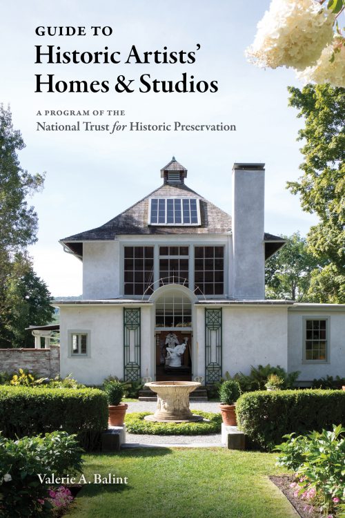 Book cover for "Guide to Historic Artists' Homes & Studios" featuring Garden walkway to a courtyard with a ceramic birdbath in the middle, leading to the entryway of a white two-story home with a dark gray roof. 