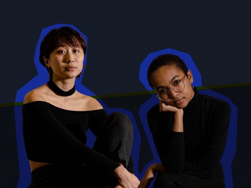 Hannah Pang (left) an asian woman with ear length hair, wearing a black shoulder less shirt, and Alissa Roach (right), a Black woman wearing a black turtleneck and large circular glasses.