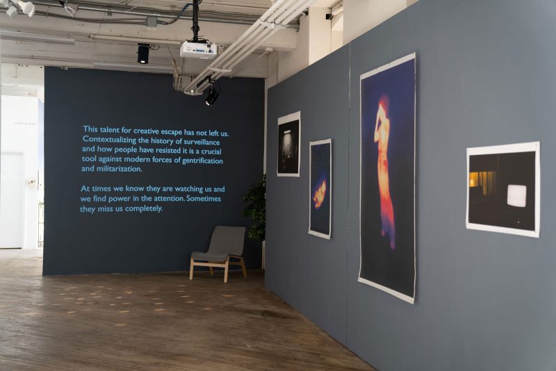 On the center and farthest wall in the exhibition space is a projection of an excerpt of text. On a closer wall to the right, four prints hang, two portraits of people in thermal heat colors; two of empty and dramatically lit interior spaces.