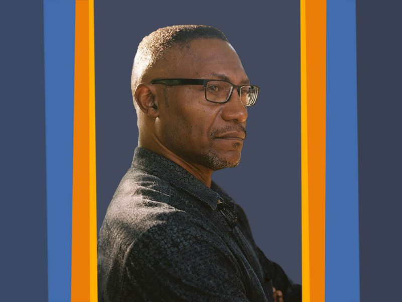 Headshot of Eric Battle, a Black man with a high fade wearing black square framed glasses and a black button up shirt, with a serious expression.