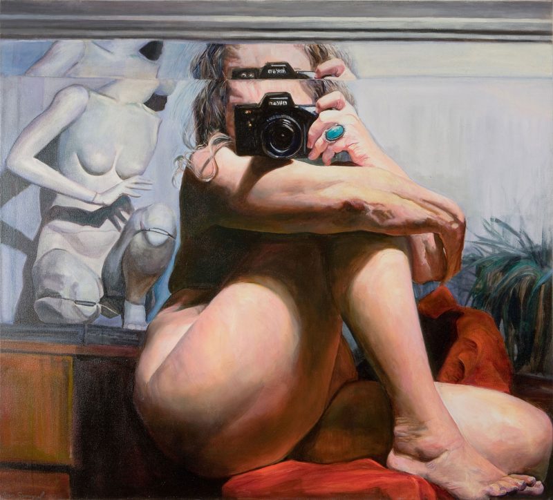 Oil painting of a nude middle aged woman with gray hair, covering her breasts with one bent leg, taking her own photo in the reflection of a mirror, next to a mannequin of a female figure behind her and a house plant.