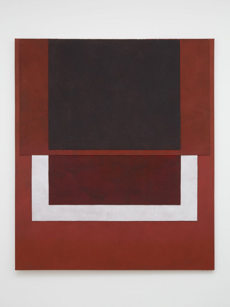 Abstract painting with a rusty red-brown background, with geometric shapes of a black square (top center) and a white angular u-shape (bottom center middle).