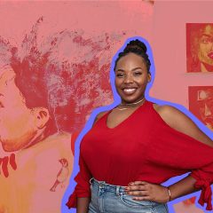 Chelsey Luster, a Black artist with long thin braids tied up in a top knot, wearing a red blouse, blue jeans, and smiling with one hand on her hip, in front of several of her paintings (stylized tinted pink for Artblog Radio).