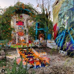 Sculpture garden filled with Aztec-inspired public sculptures and installations, with offerings of food and flowers at the foot of a large abstract figure sculpture.