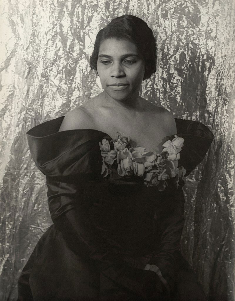 African American woman, Marian Anderson, poses for the camera in a ball gown in a photograph by Carl Vechten