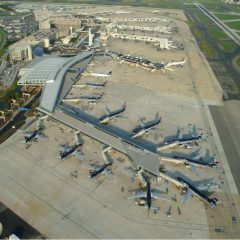 Aerial view of the Philadelphia International airport, with many planes parked on the pavement with people loading into them.