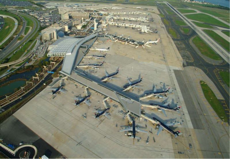Aerial view of the Philadelphia International airport, with many planes parked on the pavement with people loading into them.