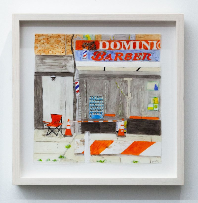 Mixed media framed work on paper of the exterior of a barber shop and the building adjacent to it; the barber shop sign says "Clean Cut DOMINIO/ BARBER"; there is a traffic cone in front of the barber shop window as well as a police barricade; in front of the adjacent building is a camping chair next to another traffic cone.