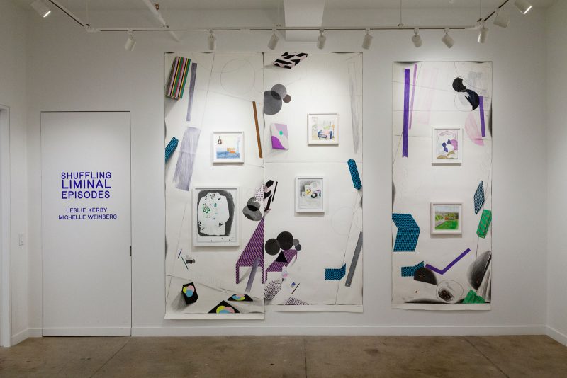 Three large works on paper hanging on one wall, two butting up directly next to one another, the third about a foot away, featuring abstractions and renderings of pictures in picture frames, framed drawings within the drawing, and geometric shapes with varying colorful patterns.