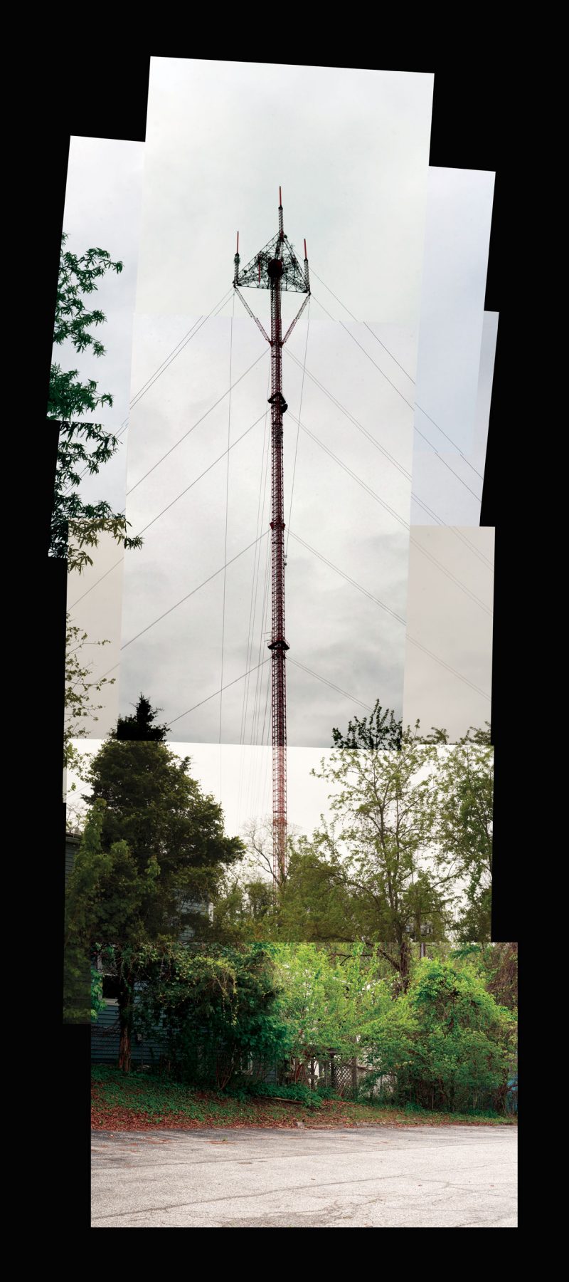 A photomontage of a thin tower against a cloudy sky, surrounded by foliage.