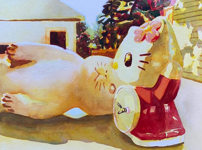 A colorful watercolor painting shows a closeup of a cat doll lying on its side with a house and trees in the background.