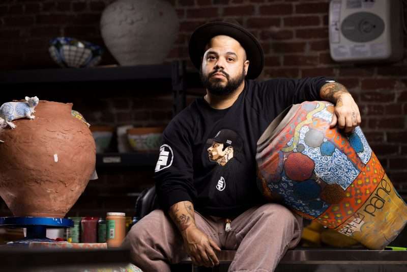 Artist Roberto Lugo poses with his ceramics in his studio.